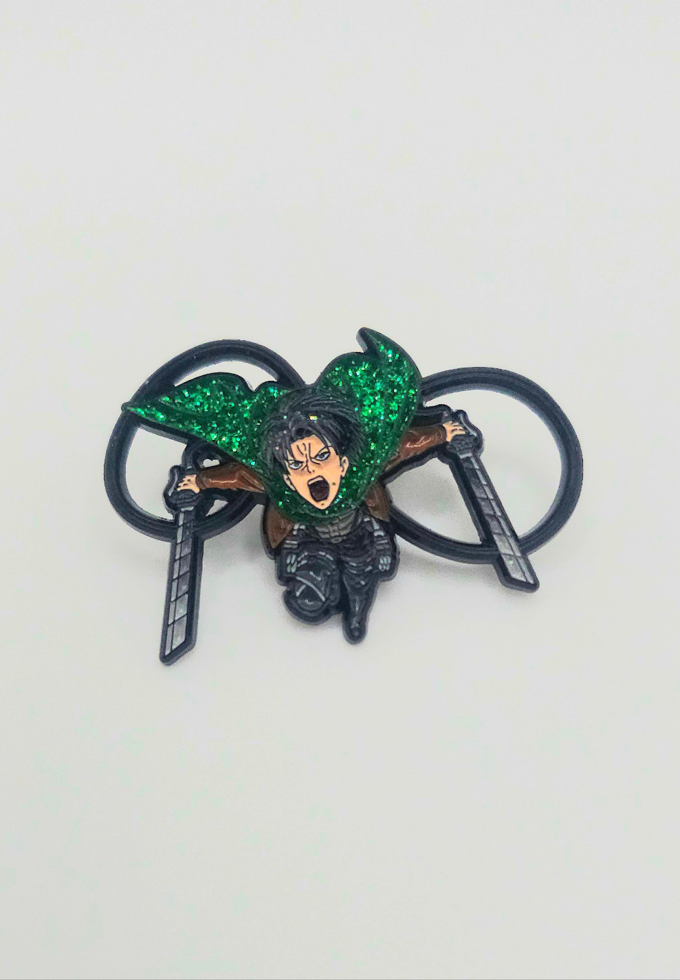 Lapel pin of Captan levi from attack on titan anime leaping into action. This pin features a glitter green cape.